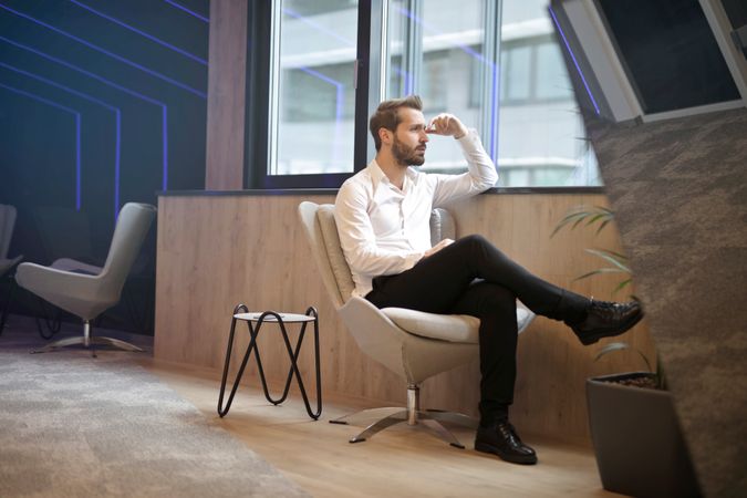 A Man Sitting Near The Window Photo
