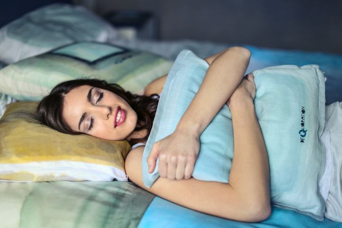 A Woman Hugging A Blue Pillow Photo