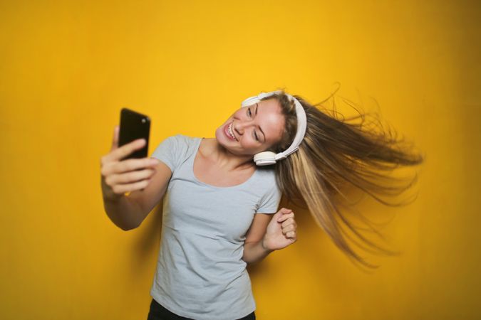 A Woman Listening To Music And Taking Snap Photo