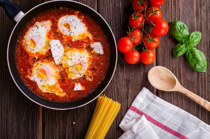 Black Frying Pan With Spaghetti Sauce Near Brown Wooden Ladle And Ripe Tomatoes Photo