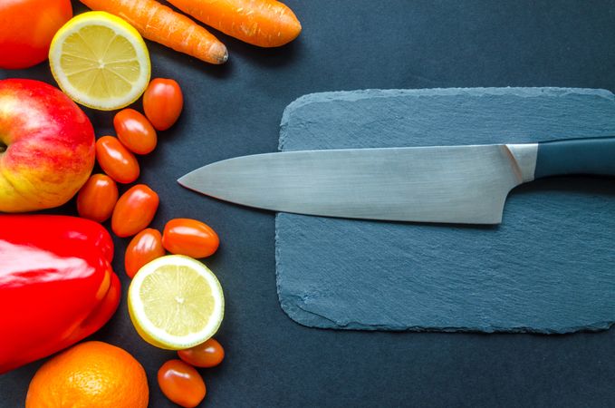Black Kitchen Knife With Fruits And Vegetable On Table Photo