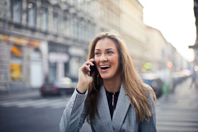 Blonde Hair Woman Wearing Gray Suit Jacket Holding Smartphone Photo