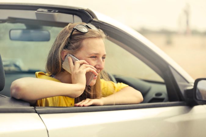 Blonde-haired Woman In Yellow T-shirt Wearing Black Sunglasses Holding Silver Smartphone Photo