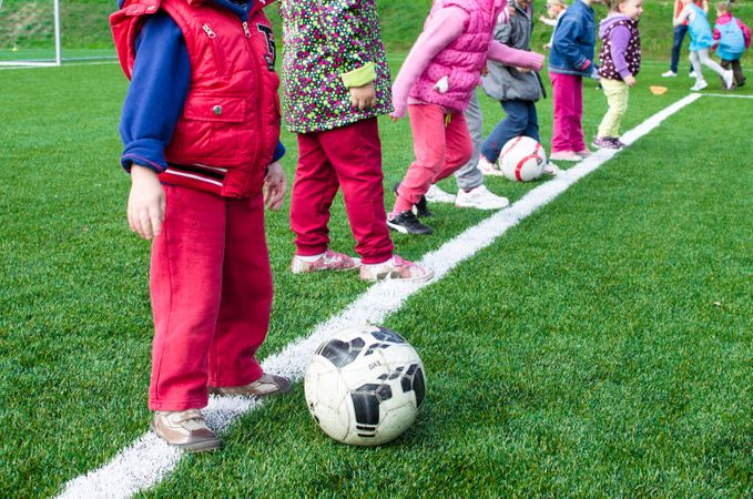 Boy Wearing Red Pant Ready To Kick Ball Photo