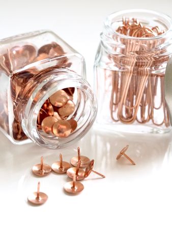 Brass Thumbacks In White Glass Container Photo