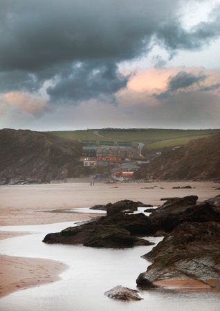 Buildings By Cliff Near Shore Under Cloudy Sky Photo