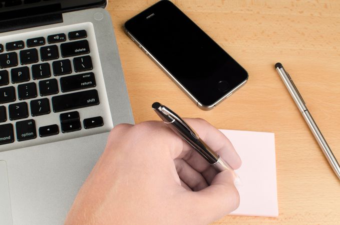 Businessman Writing On Sticky Note With Help Of Pen Photo