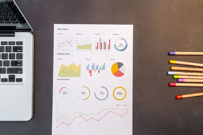 Charts And Color Pencils On Black Wooden Table Photo