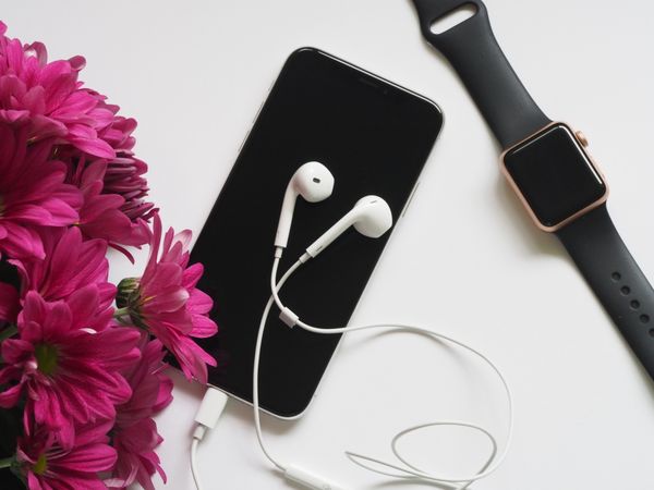 Close-Up Photography Of Earphones On Top Of Iphone 6 Near Flowers Photo