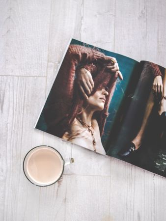 Closeup Photo Of Clear Glass Cup Near Magazine On Wooden Surface Photo