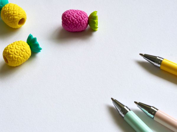 Closeup Photo Of Three Assorted-color Pens Near Pineapples Miniatures Photo
