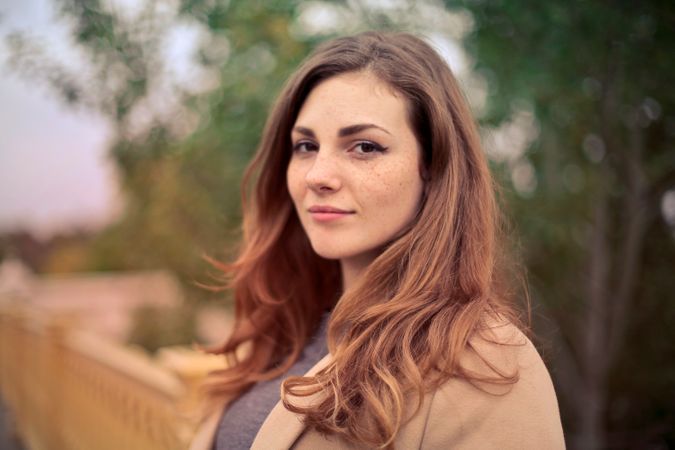 Closeup Photo Of Woman With Brown Coat And Gray Top Photo
