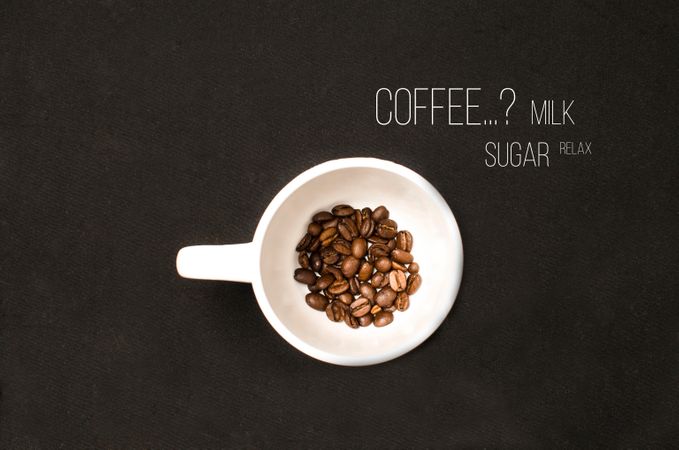 Coffee Beans In White Ceramic Cup On Black Table Photo