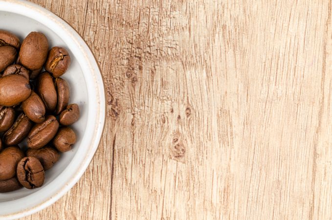 Coffee Beans On White Ceramic Bowl On Top Of Brown Wooden Surface Photo