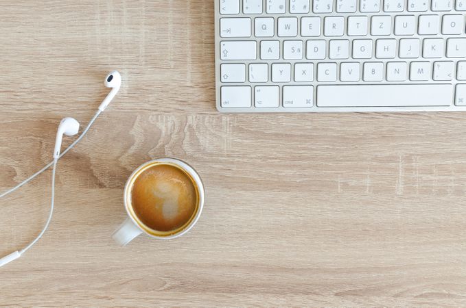 Coffee Cup On Desk Beside Earphones Photo