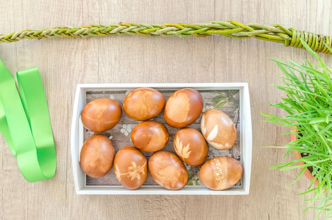 Decorated Eggs On Wooden Table Beside Green Ribbon And Chain Photo