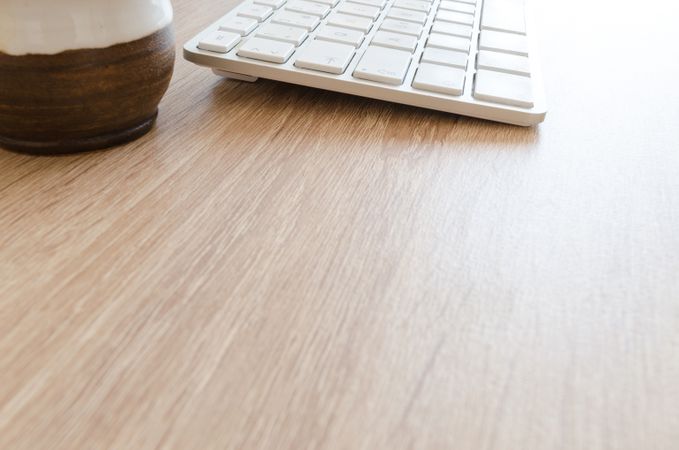 Focused Half Keyboard And Coffee Cup On Desk Photo