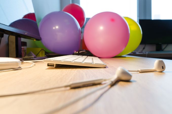 Focused Keyboard,Balloons And Earphone On Desk Photo