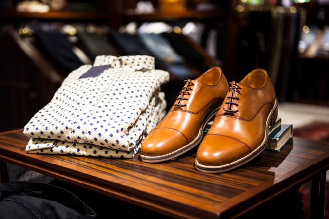 Formal Shirt And Leather Shoes On Wooden Table In Clothing Store Photo
