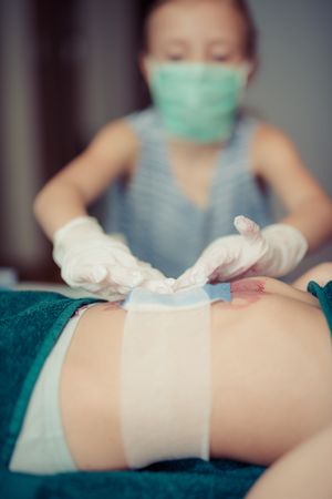 Girl Doing Plaster To Doll While Playing Doctor Doctor Photo