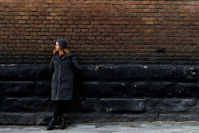 Girl Giving Pose Standing Beside Bricks Wall Photo