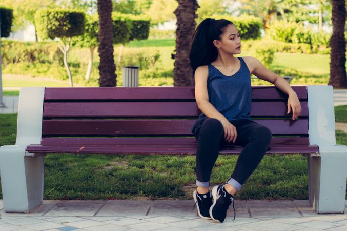 Girl Sitting On Garden Bench And Giving Pose Photo