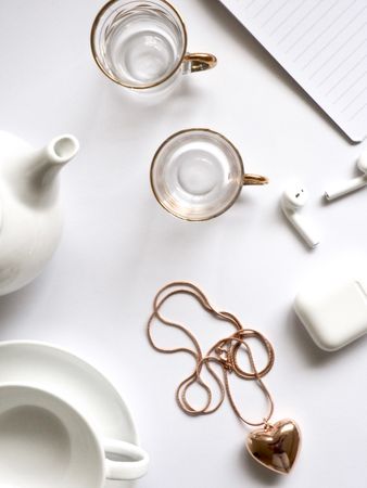 Gold-colored Heart Pendant Necklace Beside Two Glass Mugs On Table Photo