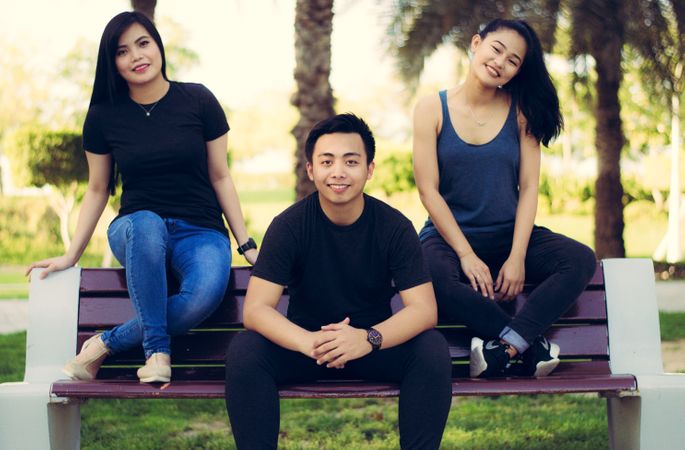 Group Of Friends Sitting On Bench In Garden Photo
