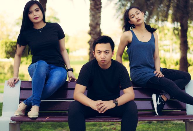 Group Of Friends Sitting On Bench In Garden Photo