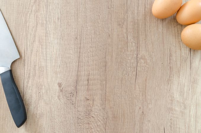 Knife And Boiled Eggs On Different Corners On Wooden Table Photo