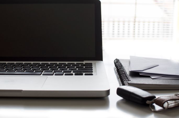 Laptop With Black Spiral Book On Table Photo