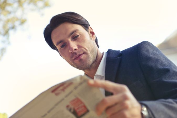 Low Angle Shot Of Man Reading Newspaper Photo