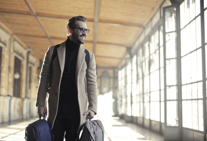 Man In Brown Robe Carrying Bag Smiling Photo