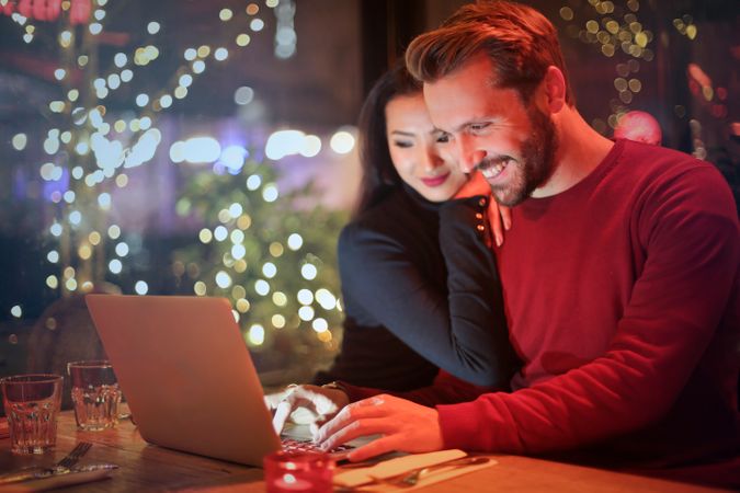 Man In Red Long-sleeved Shirt Near Woman And Watching Photos Together Photo