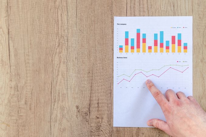 Man Point On Graph And Analysed It On Wooden Table Photo