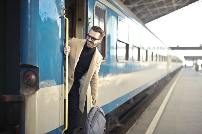 Man Wearing Beige Overcoat Inside Train Photo