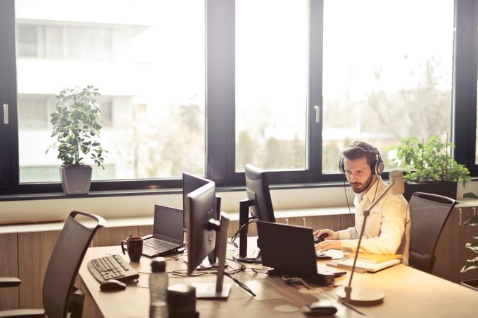 Man With Headphones Facing Computer Monitor Photo
