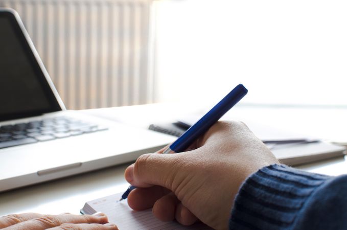 Man Writing On Notebook At Office Photo