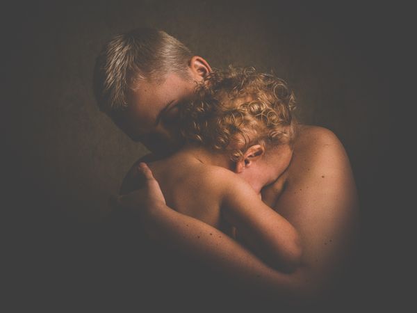 Photo Of Topless Person Carrying Curly Haired Child Photo