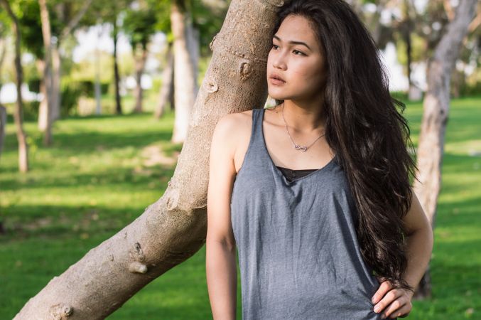 Photography Of Girl Wearing Racerback Top While Standing Near Tree In Garden Photo