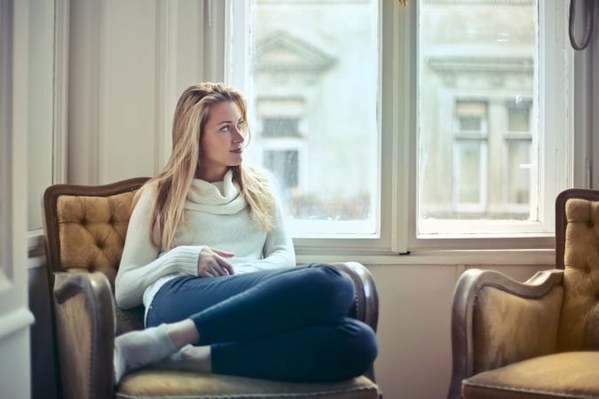 Photography Of Woman Sitting On Chair Near Window Photo