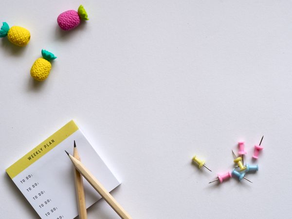 Pink, Yellow, And Blue Push Pins And Brown Pencil On White Table Photo