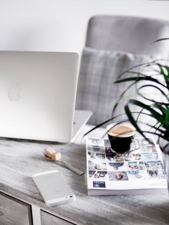 Silver Iphone Beside Book Under Cup Beside Silver Macbook Photo