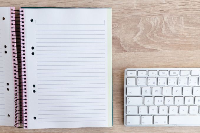 Spiral Book Beside White Keyboard Photo