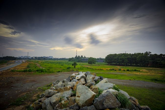 Stratus Clouds Above Green Grass And Beige Stones Photo