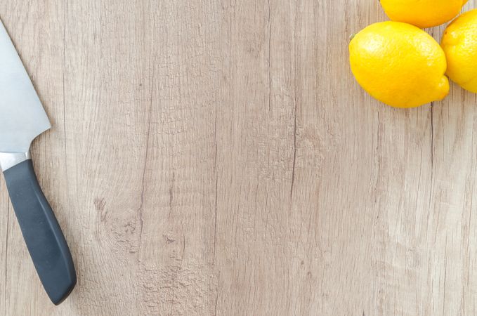 Three Lemons With Knife On Board Photo