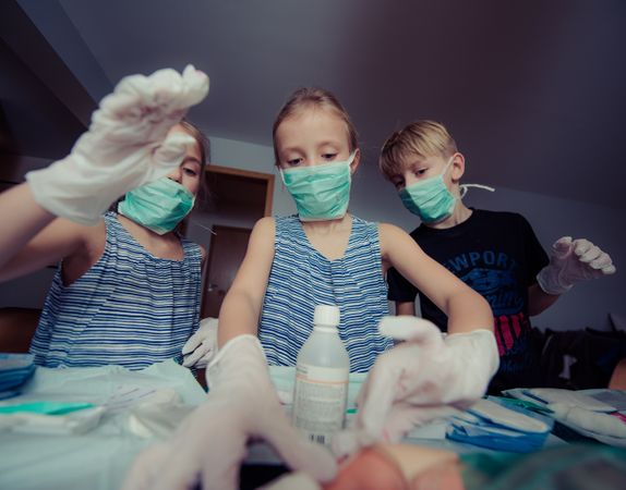 Three Siblings Wearing Mask And Playing Surgeon Photo