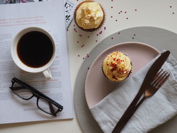 Top-view Photograph Of Two Cupcakes, Cup, And Eyeglasses Photo