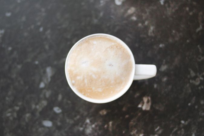 Top View Photography Of Cappuccino Coffee Cup On Black Marble Photo