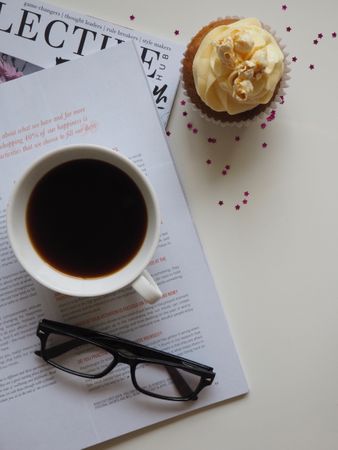 White Ceramic Cup With Coffee On Top Of Opened Book And Near Eyeglasses Photo